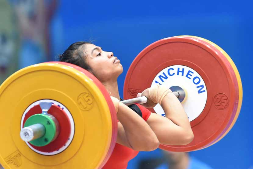 Atlet angkat besi putri Indonesia, Sri Wahyuni Agustiani, melakukan clean&Jerk; pada angkat besi 48 kg Asian Games 2014 di Moonlight Garden Venue, Inchoen, Korsel, Sabtu (20/9). 