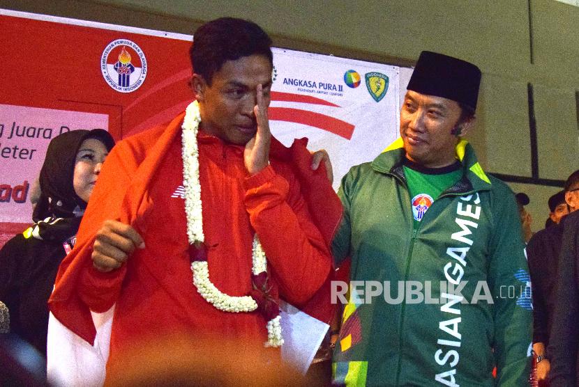 Atlet Athletik Indonesia Lalu Muhammad Zohri (kiri) bersama menteri pemuda dan olaharaga Indonesia Imam Nahrawi (kanan) menahan air mata saat tiba di Indonesia dari Finlandia di Bandara Internasional Soekarno Hatta, Tangerang,Banteng,Selasa (17/7).