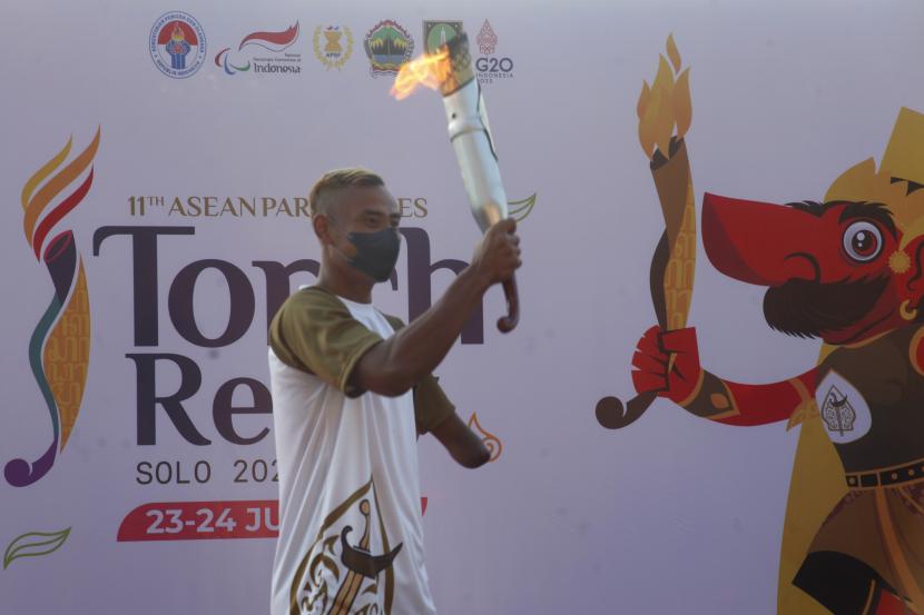 Atlet cabor para atletik National Paralympic Committee (NPC) Indonesia Rizal Bagus Saktyono membawa api obor saat torch relay atau pawai obor ASEAN Para Games 2022 di Stadion Sriwedari, Solo, Jawa Tengah, Ahad (24/7/2022). Indonesia menjadi tuan rumah ajang ASEAN Para Games XI 2022 yang akan mempertandingkan 14 cabang olahraga dan diikuti 11 negara-negara Asia Tenggara pada 30 Juli-6 Agustus 2022 mendatang.