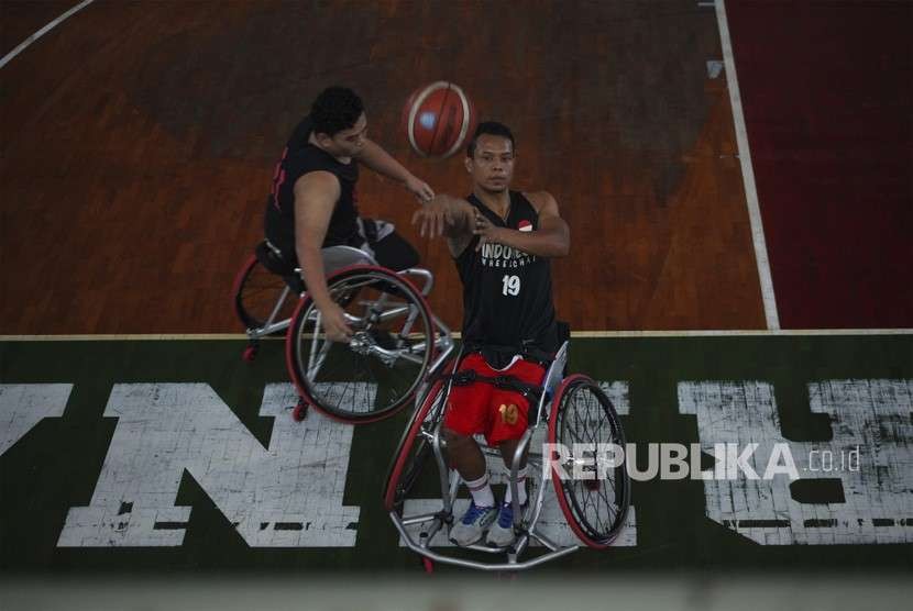 Atlet disabilitas cabang Wheelchair Basketball Indonesia Idrus (kiri) melempar bola ke ring saat mengikuti pemusatan latihan Asian Para Games di GOR Sritex Solo, Jawa Tengah, Rabu (26/9).