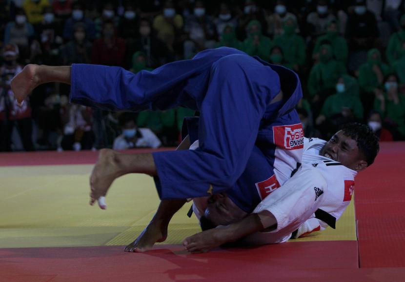 Atlet Judo Putra Papua, Ilham Fadillah (biru) saat menghadapi atlet Kalimantan Barat, Beta Awari, dalam nomor final kelas 55 kg PON XX Papua di GOR Emeneme, Timika, Rabu(29/9).