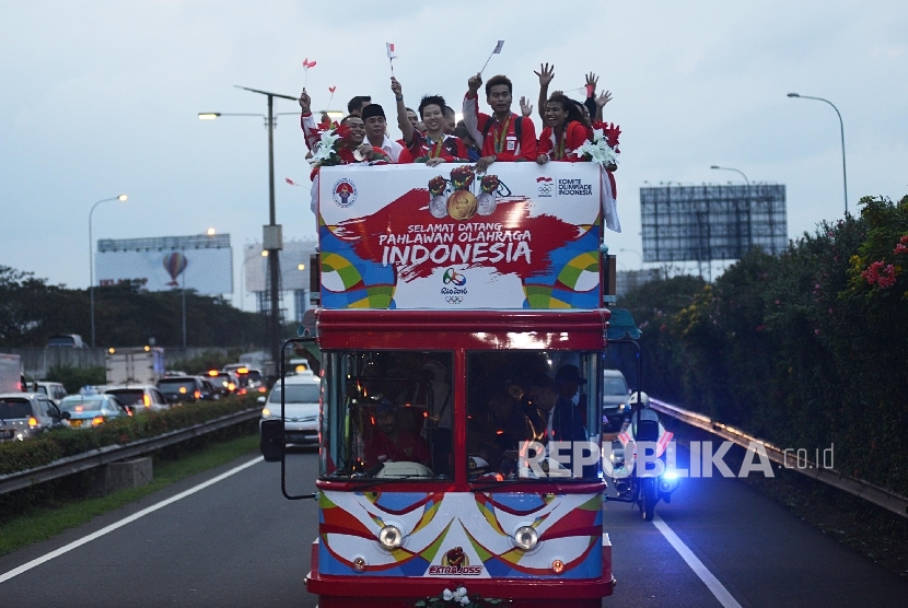 Atlet Olimpiade yang diarak menggunakan Bandung Tour On Bus (Bandros) menyapa warga saat tiba di Terminal 3 baru Bandara Soekarno-Hatta, Tangerang, Banten, Selasa (23/8).