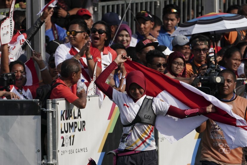 Atlet panahan Indonesia Diananda Choirunnisa membawa bendera merah putih seusai mengalahkan lawannya asal Filipina Nicole Marie Tagle pada final nomor recurve putri di Synthetic Turf Fild, Kawasan Bukit Jalil, Malaysia, Ahad (20/8). 
