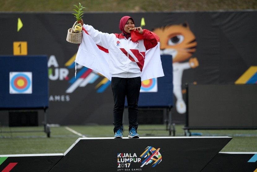 Atlet panahan putri Indonesia Sri Ranti menggigit medali emas setelah menjuarai final nomor compound putri SEA Games XXIX di Synthetic Turf Fild, kawasan Stadion Bukit Jalil, Kuala Lumpur, Malaysia, Rabu (16/8). 