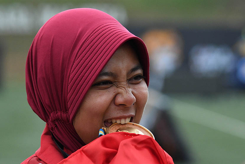 Atlet panahan putri Indonesia Sri Ranti menggigit medali emas setelah menjuarai final nomor compound putri SEA Games XXIX di Synthetic Turf Fild, kawasan Stadion Bukit Jalil, Kuala Lumpur, Malaysia, Rabu (16/8). 