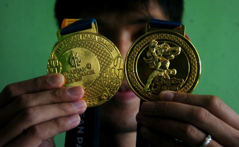Atlet paralympic Banyu Tri Mulyo menunjukkan dua medali emas di rumahnya. Indonesia menempati posisi puncak setelah merebut 426 medali dengan rincian 175 medali emas, 144 medali perak, dan 107 medali perunggu. (ilustrasi)