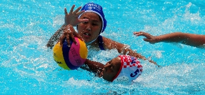 Atlet polo air putri Indonesia, Melviani Rayina Eka (5), berebut bola dengan pemain Malaysia pada pertandingan cabang polo air Sea Games 2011 di kolam renang Lumban Tirta, Pelambang, Sumatera Selatan.