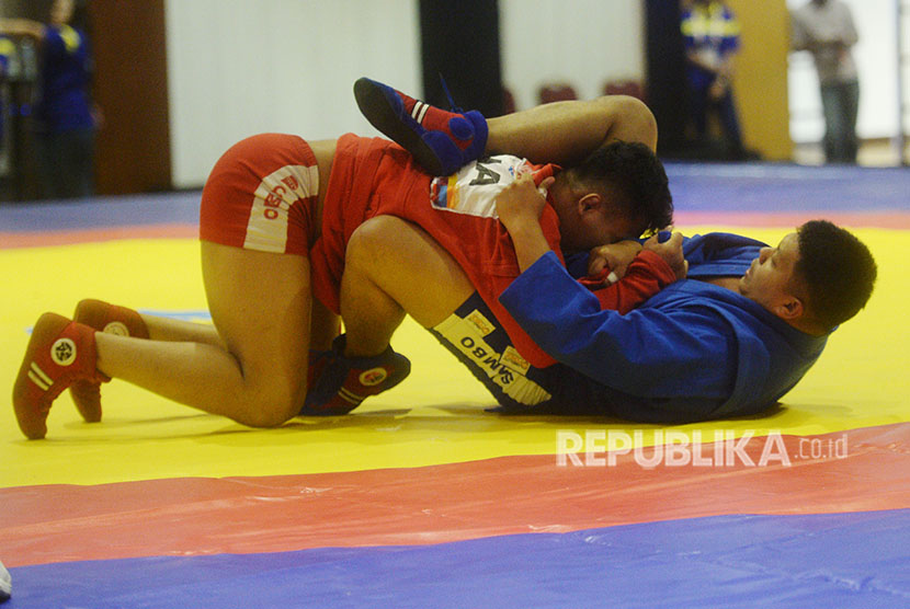 Atlet Sambo Indonesia Rio Akbar Bahari (atas) beradu jurus dengan atlet sambo Filipina Ace Larida dalam nomor 90 kg putra Kejuaraan Sambo se-ASEAN di Jakarta, Rabu (11/4). 