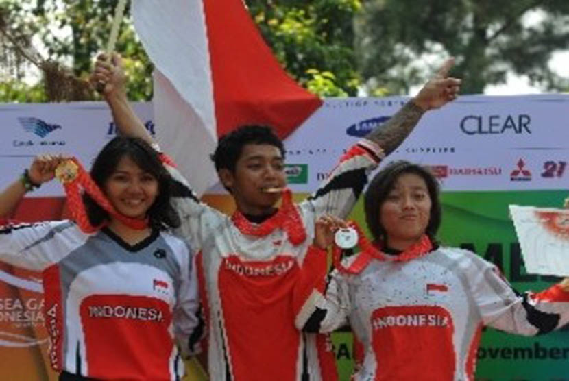 Atlet sepeda MTB Down Hill putra Indonesia, Purnomo (tengah), bersama rekannya Risa Suseanty (kiri) dan Fitriyanti Riyanti memgang medali SEA Games XXVI mereka di Sebek, Gunung Pancar, Bogor, Jabar, Sabtu (12/11).