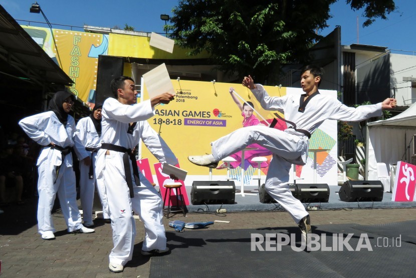 Atlet Taekwondo melakukan aksinya saat Sosialisasi Asian Games XVIII/2018 di Car Free Daya (CFD), Jl Ir H Djuanda, Kota Bandung, Ahad (3/12). 
