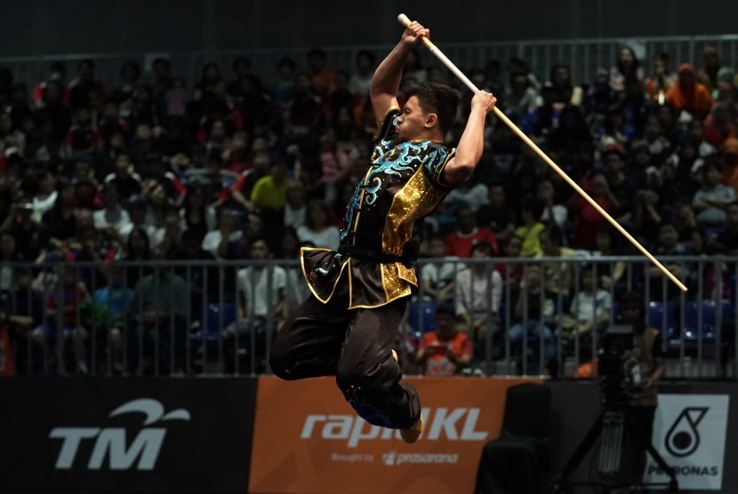 Atlet wushu Indonesia Achmad Hulaefi memperagakan jurus dalam nomor gabungan gunshu dan daoshu.