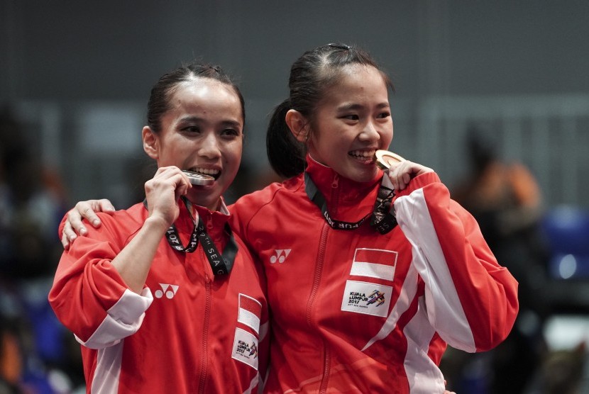 Atlet Wushu Indonesia Felda Elfira Santoso (kanan) dan Monica Fransisca Sugianto menggigit medali ketika penganugerahan juara Wushu nomor Daoshu putri SEA Games XXIX di KLCC, Kuala Lumpur, Malaysia, Senin (21/8). 