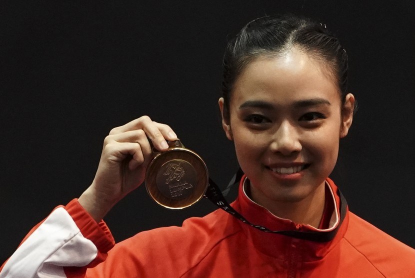 Atlet wushu Indonesia Lindswell Kwok memegang medali ketika upacara penyerahan medali wushu nomor Taijijian putri di KLCC, Kuala Lumpur, Malaysia, Senin (21/8). 