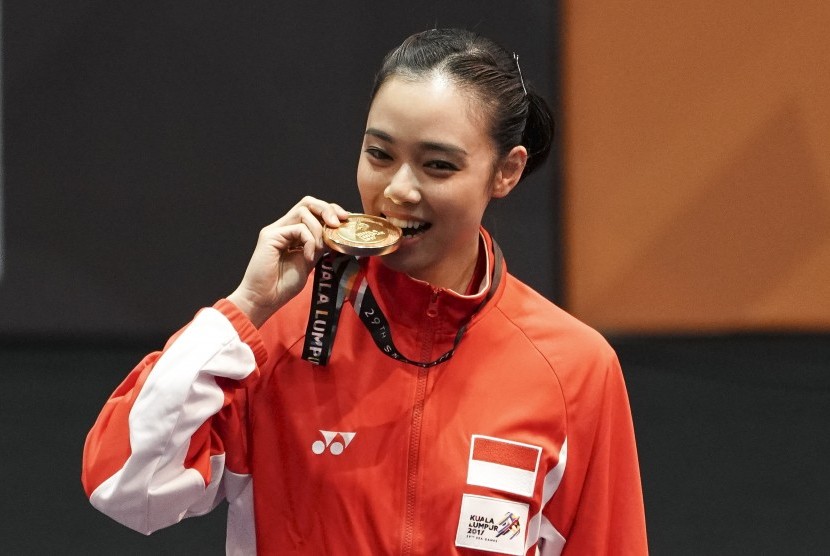 Atlet wushu Indonesia Lindswell Kwok menggigit medali ketika upacara penyerahan medali wushu nomor Taijijian putri di KLCC, Kuala Lumpur, Malaysia, Senin (21/8). 