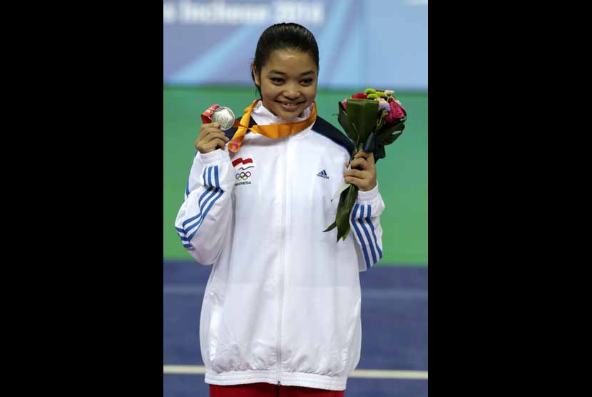 Atlet wushu Indonesia, Wasni Juwita Niza, memperlihatkan medali peraknya usai laga final wushu putri kelas Nandao Asian Games 2014 di Ganghwa Dolmens Gymnasium, Incheon, Sabtu (20/9). 