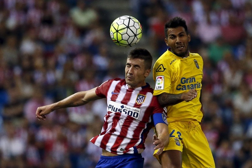 Atletico Madrid's Gabi (L) and Las Palmas' Jonathan Viera fight for a high ball during their Spanish first division soccer match at Vicente Calderon stadium in Madrid, Spain, August 22, 2015