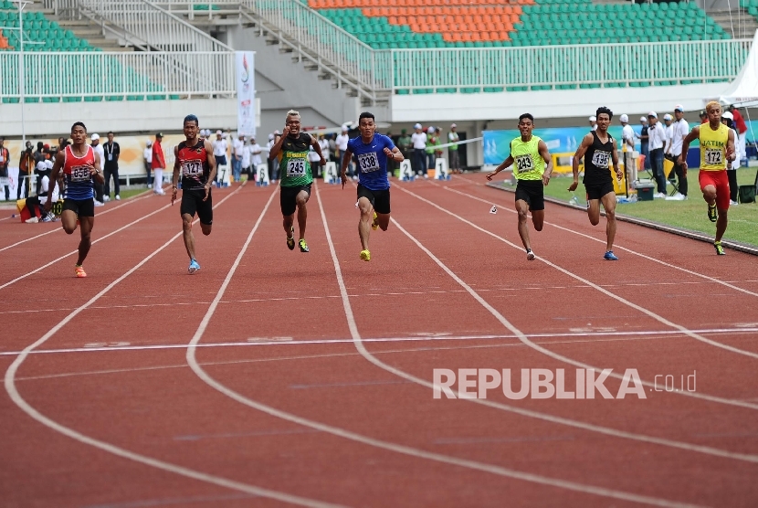 Atlet melakukan adu kecepatan pada kelas lari 100 meter putra di stadion Pakansari, Cibinong, Jawa Barat, Kamis (22/9). 