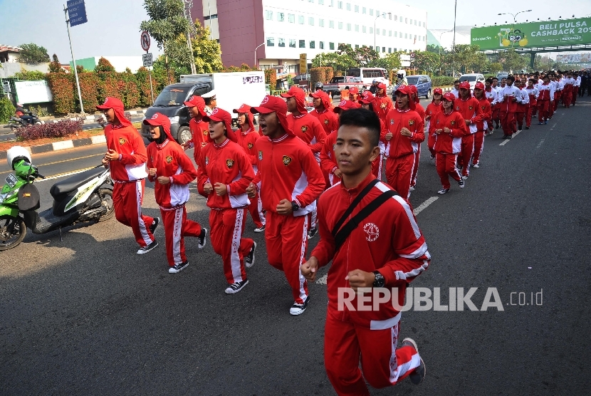  Atlit peserta mengikuti kirab Api PON XIX saat melintasi Jl Ahmad Yani, Bekasi, Jawa Barat. Selasa (13\9).