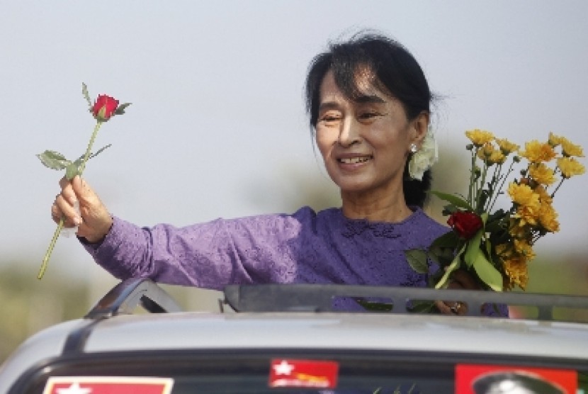 Aung San Suu Kyi menggenggam mawar yang diberikan para pendukungnya kala mengunjungi daerah pemilihan Kawhnu.
