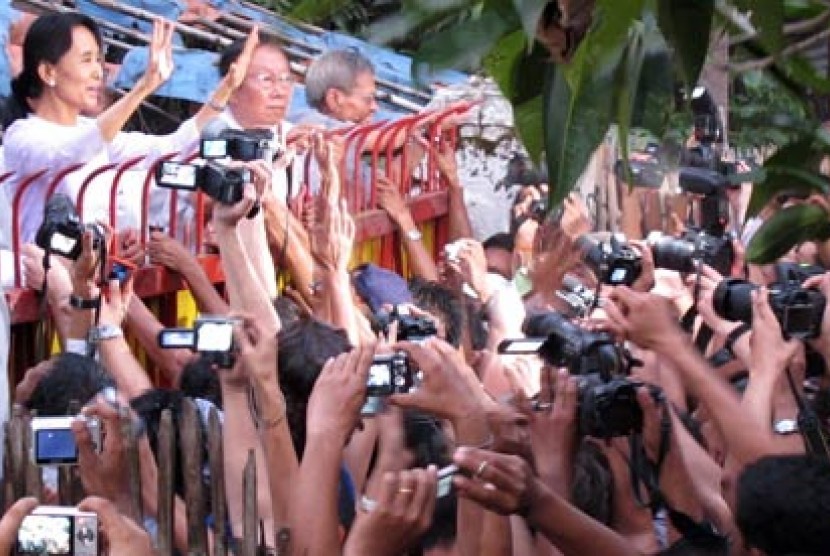 Aung San Suu Kyi saat menyapa pendukungnya di gerbang rumah bersejarah