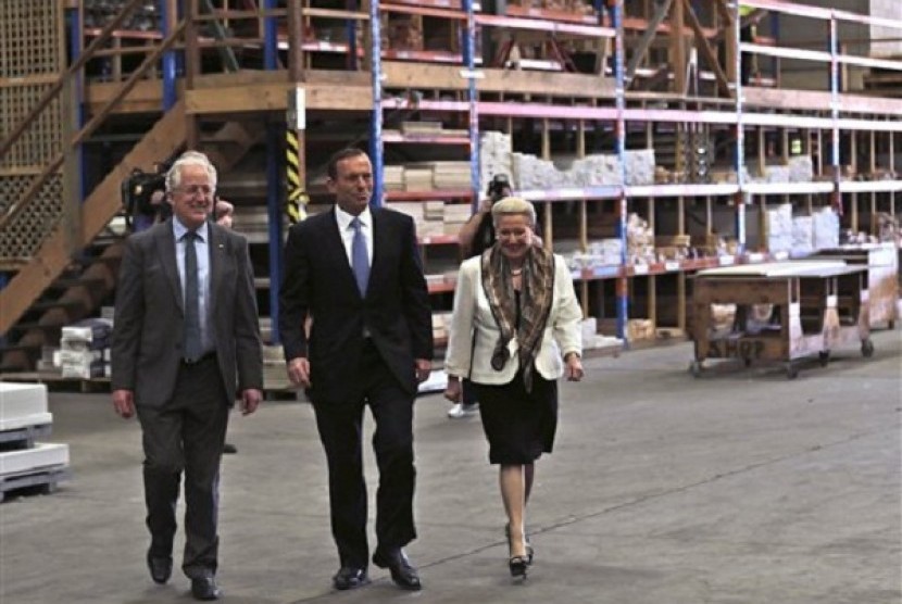 Australia's opposition leader Tony Abbott, center, walks with Liberal candidate Bronwyn Bishop, right, through a hardware store in Sydney Wednesday, Sept. 4, 2013. 