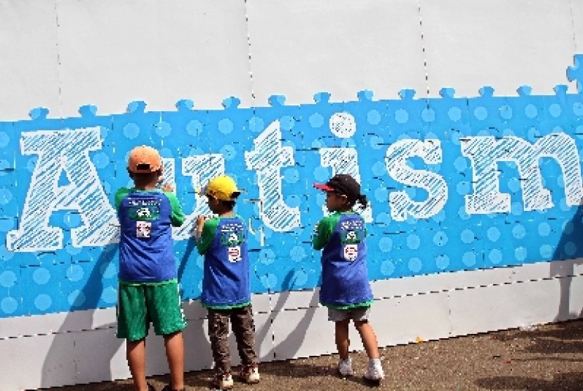Anak-anak melihat tembok bertuliskan Autism dalam rangka peringatan Hari Autis Sedunia (ilustrasi). Seorang terapis di Depok, Jawa Barat ditetapkan sebagai tersangka setelah kedapatan menjepit kepala pasien ciliknya dengan paha.