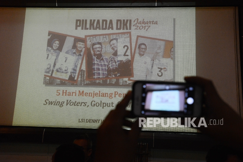 Awak media mengabadikan slide yang ditunjukan oleh peneliti Lingkaran Survey Indonesia (LSI) Ardian Sopa saat menggelar diskusi temuan survey swing voters, golput dan money politik di Kantor LSI, Jakarta, Jumat (10/2).