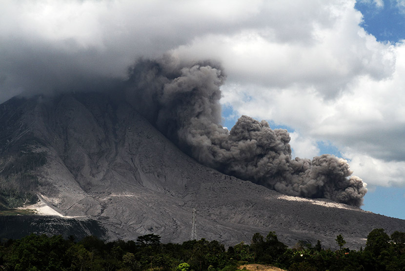 Awan panas meluncur dari puncak Gunung Sinabung ketika terjadi guguran kubah lava terlihat dari Desa Tiga Pancur, Karo, Sumatera Utara, Minggu (10/1).
