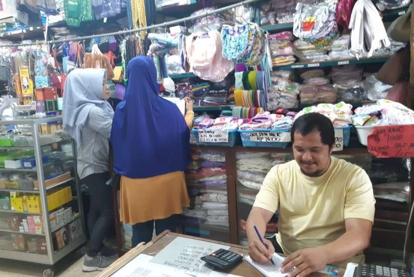 Azzan Awod Bazri, pemilik pusat oleh-oleh haji/umrah Toko Apeh, Jl RE Martadinata, Kabupaten Purwakarta, sedang melayani pembeli, Jumat (10/8). 