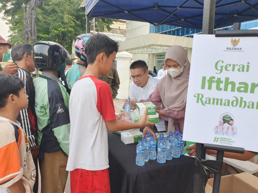 Badan Amil Zakat Nasional (Baznas) membagikan paket Takjil Berkah Ramadhan kepada para warga dan pengguna jalan di Matraman Raya, Jakarta, jelang waktu berbuka puasa.