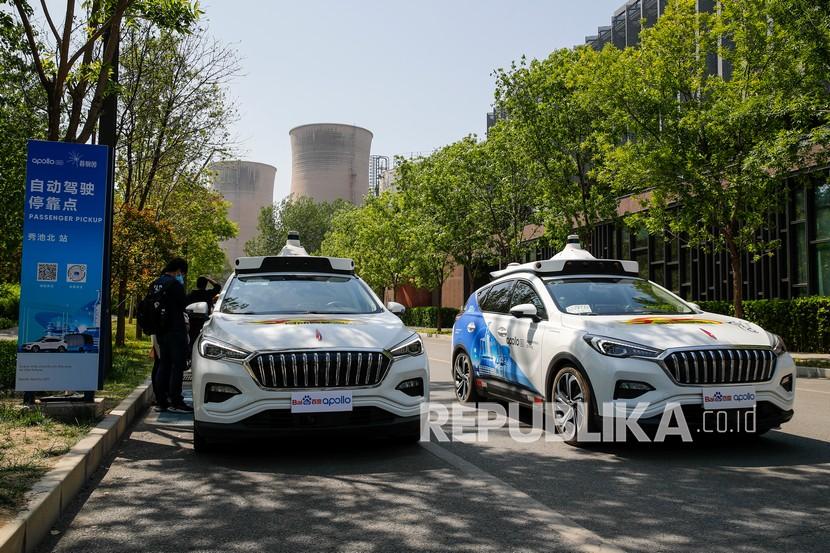 Baidu Apollo Robotaxis melewati tempat penjemputan penumpang di Shougang Park di Beijing, Ahad (2/5).. Raksasa teknologi China Baidu meluncurkan layanan taksi tanpa pengemudi berbayar pada hari Ahad, menjadikannya perusahaan pertama yang mengkomersialkan operasi mengemudi otonom di China .