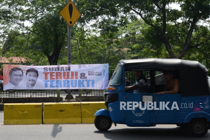  Bajaj melintas di sebelah spanduk duet Ahok-Djarot terpampang di Jalan Sultan Agung, Jakarta Pusat, Kamis (28/7).  (Republika/ Yasin Habibi)