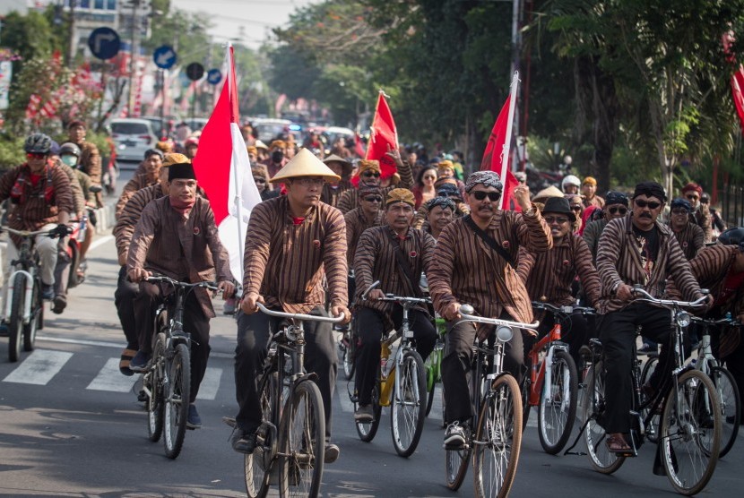 Bakal calon anggota legislatif dan simpatisan Partai Demokrasi Indonesia Perjuangan (PDIP) menaiki sepeda ontel menuju kantor Komisi Pemilihan Umum (KPU) untuk mendaftar calon anggota legislatif di Solo, Jawa Tengah, Selasa (17/7). 