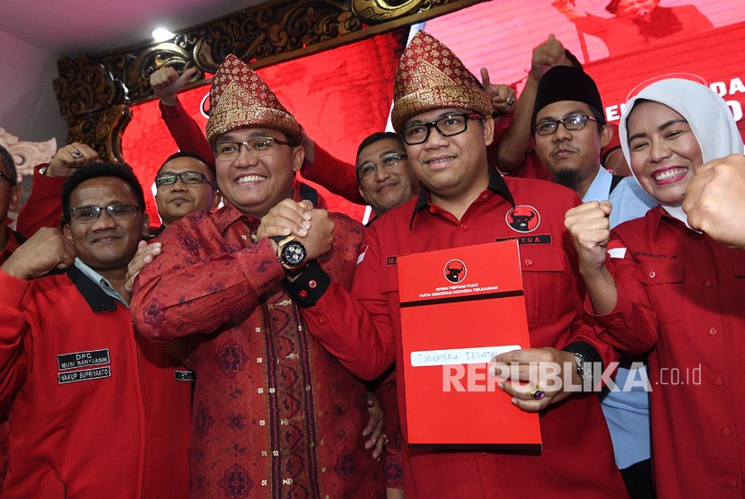 Bakal calon Gubernur dan Wakil Gubernur Sumsel Dodi Reza Alex Noerdin (ketiga kiri) dan Giri Ramanda Kiemas (ketiga kanan) berjabat tangan usai menerima berkas rekomendasi dukungan di kantor DPP PDIP, Lenteng Agung, Jakarta Selatan, Ahad (7/1). 