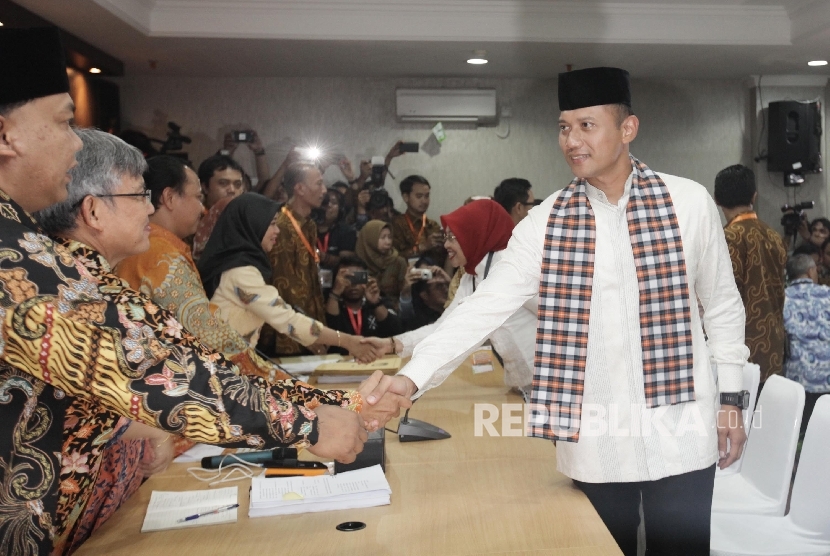 Bakal Calon Gubernur DKI Agus Harimurti Yudhoyono (kanan) dan Bakal Cawagub Sylviana Murni (kedua kanan) didampingi pimpinan partai pengusung menyalami pimpinan KPUD sebelum menyerahkan dokumen di KPUD DKI Jakarta, Jumat (23/9) malam.