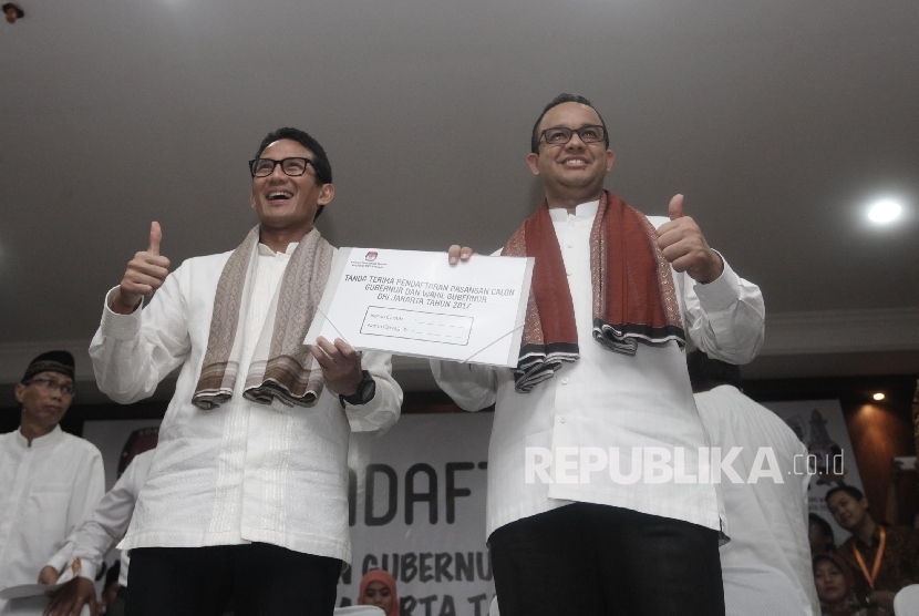 Bakal calon gubernur DKI Anies Baswedan (kanan) dan bakal cawagub Sandiaga Uno (kiri) menunjukkan dokumen pendaftaran di KPUD DKI Jakarta, Jumat (23/9) malam. 