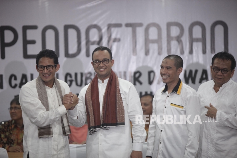 Bakal Calon Gubernur DKI Anies Baswedan (kedua kiri) dan Bakal Cawagub Sandiaga Uno (kiri) bersalaman seusai menyerahkan dokumen pendaftaran di KPUD DKI Jakarta, Jumat (23/9) malam.