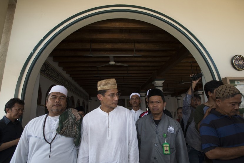 Bakal Calon Gubernur DKI Jakarta Sandiaga Uno (tengah) berjalan bersama pengurus Masjid Jami' Keramat Luar Batang, Jakarta, Jumat (8/4).