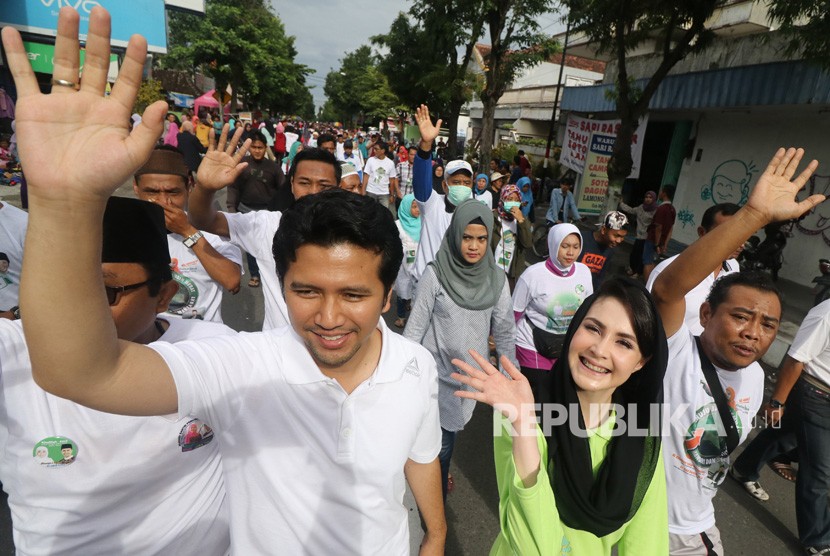 Bakal calon Wakil Gubernur Jawa Timur Emil Elestianto (kiri) didampingi istri Arumi Bachsin (kedua kiri) mengikuti jalan sehat dan deklarasi dukungan, di Pare, Kediri, Jawa Timur, Ahad (21/1). 