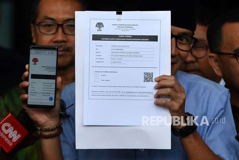 Bakal calon wakil presiden Pilpres 2019 Sandiaga Uno (kanan) menunjukkan tanda terima Laporan Harta Kekayaan Penyelenggara Negara (LHKPN) di gedung KPK, Jakarta, Selasa (14/8).