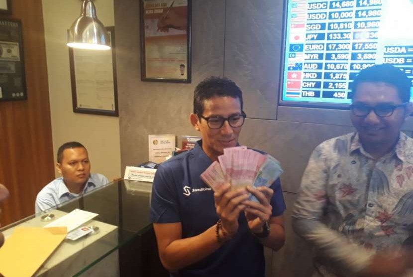 Bakal calon wakil presiden Sandiaga Salahuddin Uno setelah menukarkan sejumlah uang dolar di penukaran uang Dua Sisi, Plaza Senayan, Jakarta, Kamis (6/9).