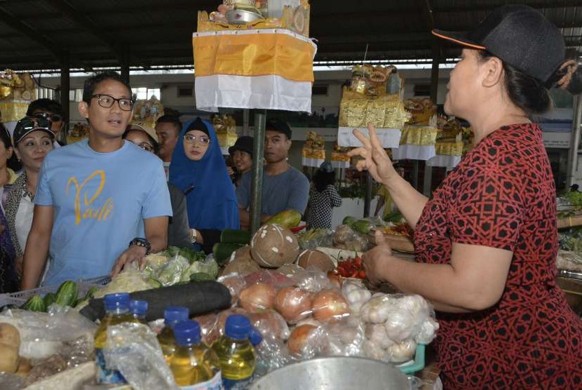 Bakal Calon Wakil Presiden Sandiaga Uno (kiri) berbincang dengan pedagang saat mengunjungi Pasar Sindhu di Sanur, Denpasar, Bali, Minggu (9/9).