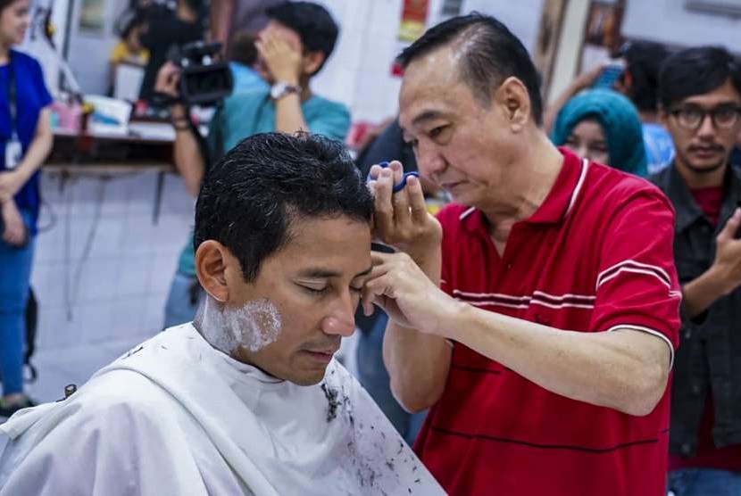 Bakal calon Wakil Presiden Sandiaga Uno memotong rambut di pangkas rambut Ko Tang, Glodok, Jakarta, Selasa (11/9). 