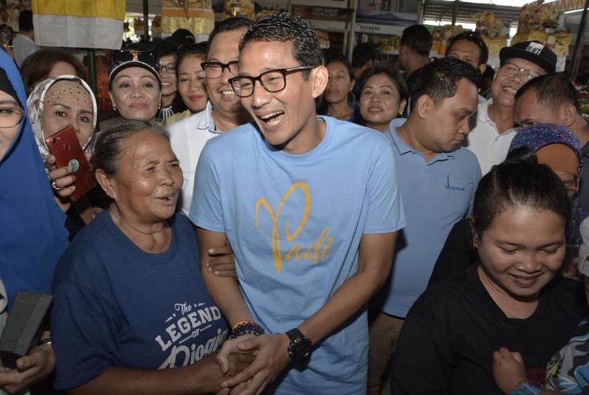 Bakal Calon Wakil Presiden Sandiaga Uno (tengah) berbincang dengan pedagang saat mengunjungi Pasar Sindhu di Sanur, Denpasar, Bali, Minggu (9/9).