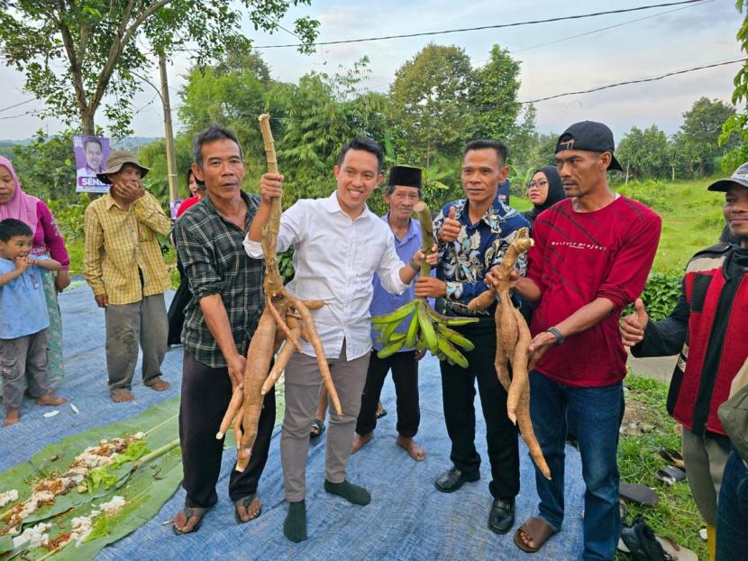 Bakal calon wali kota Bogor, Sendi Fardiansyah, saat menerima hadiah pisang dan singkong dari warga.