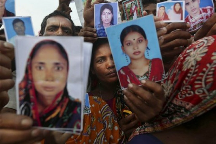 Bangladeshi relatives of workers missing in a building that collapsed Wednesday hold pictures of loved ones at a makeshift morgue in a schoolyard in Savar, near Dhaka, Bangladesh, Saturday, April 27, 2013. 