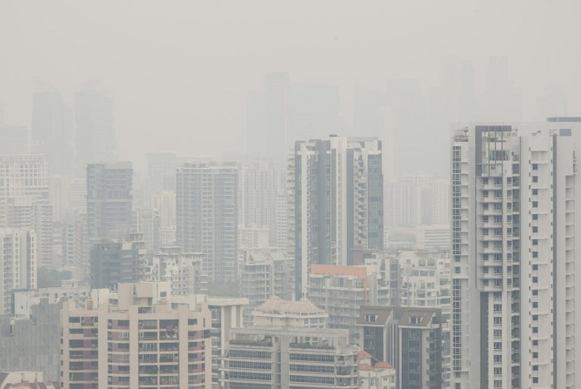 Bangunan menjulang di distrik finansial Singapura tampak terselimuti kabut asap, Senin (16/9). Kebakaran hutan di Indonesia menjadi penyebab kabut asap di Singapura.