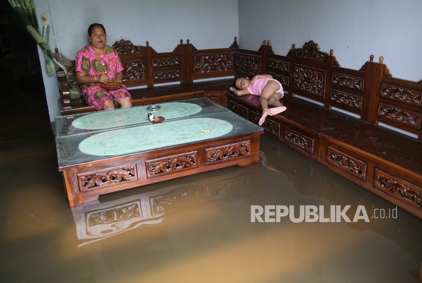 Banjir Di Kediri.  Warga beristirahat di dalam rumahnya yang terendam banjir di Desa Papar, Kediri, Jawa Timur, Kamis (21/3/2019).