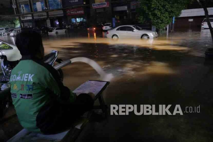 Pengemudi Gojek menunggu banjir reda di kawasan Kemang, Jakarta, hingga Ahad (28/8) dinihari. 