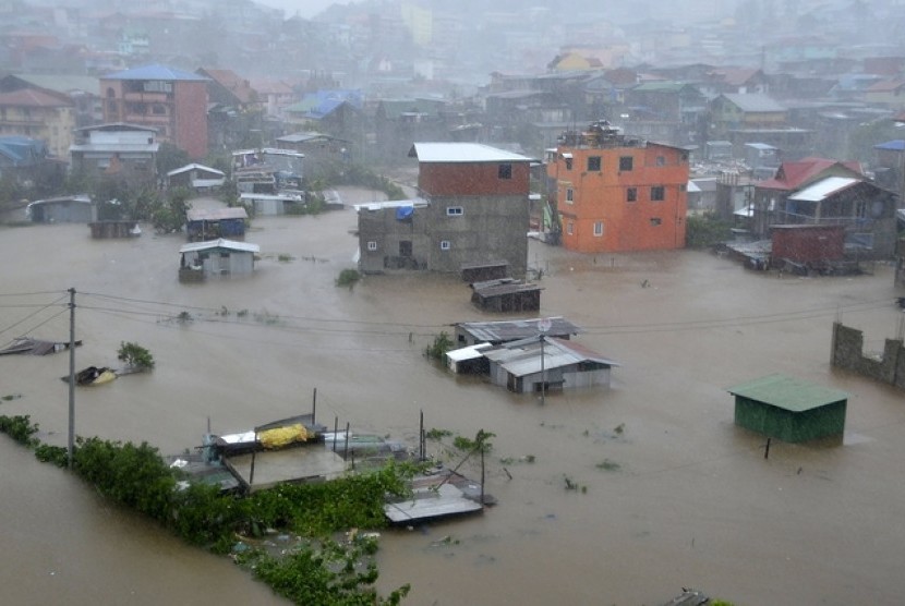 Banjir merendam sejumlah rumah di Kota Bauguio akibat imbas Topan Koppu di utara Filipina, Senin (19/10).